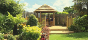 2.5 metre thatched roof gazebo on raised deck in garden